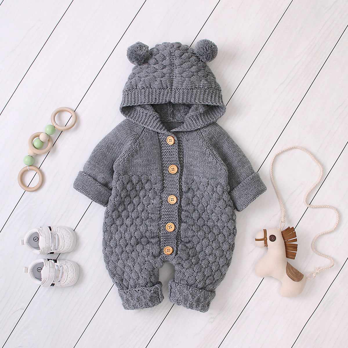 Combinaison-grenouillère bébé à capuche tricotée et boutonnée